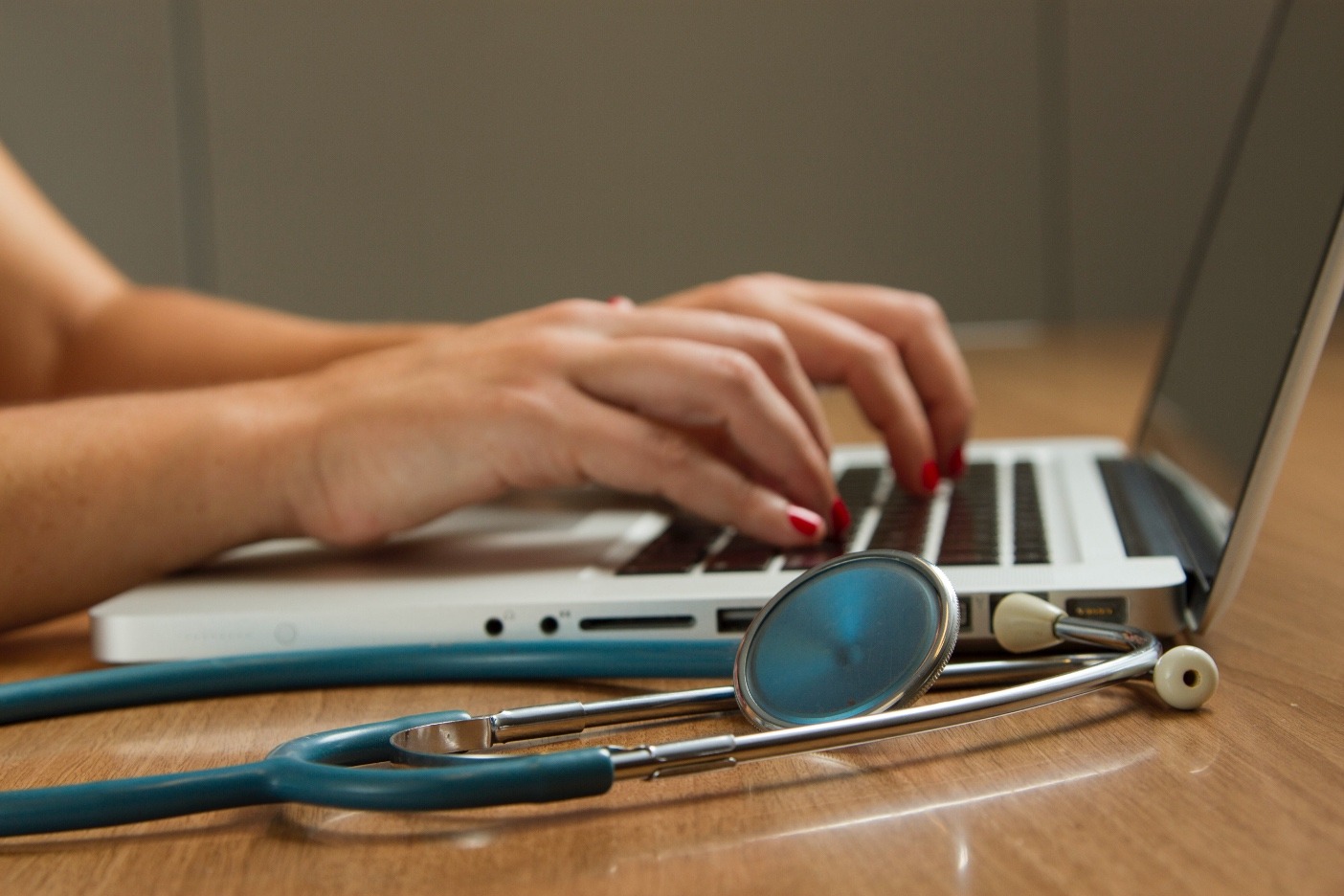 medical professional typing on laptop